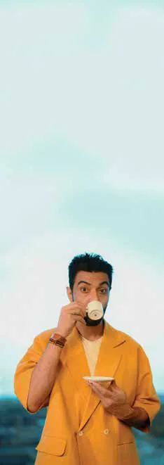 Ranveer Brar in a yellow outfit, drinking from a cup