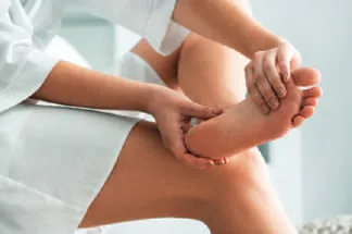 Hands massaging a leg with oil