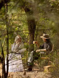 Two people having tea at a table in the forest