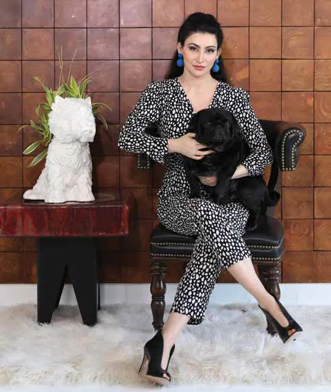 Shalini Passi seated beside a sculpture