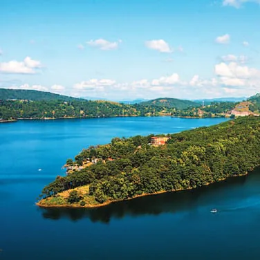 An island in a blue lake among forested hills