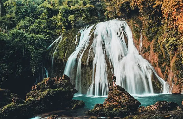 A waterfall pouring into a green pool