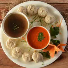 A plate of momos with two dipping sauces