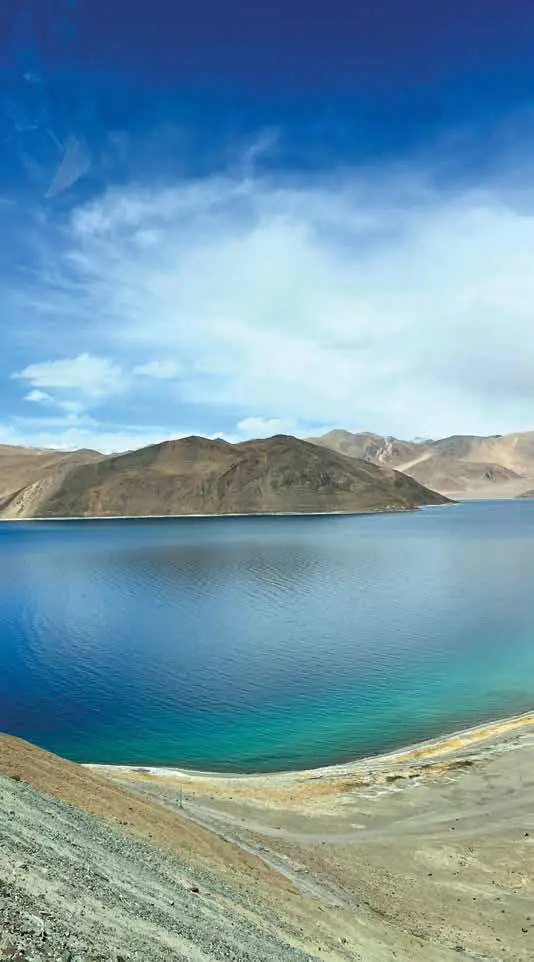 A turquoise lake below bare mountains