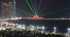 Laser beams over a waterfront concert venue at night