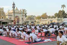 Rows of people doing yoga on mats in front of a palace