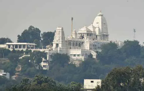 A white marble temple on a hilltop above the city