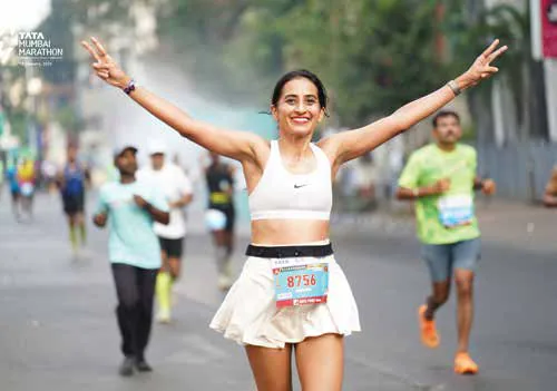 Vineeta Singh raising her arms as she runs a marathon