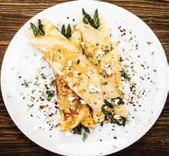 Crepes filled with asparagus on a white plate