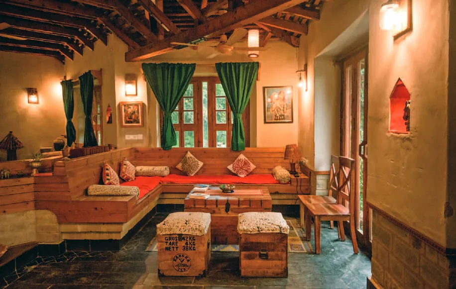 A lodge sitting room with wooden beams and green curtains