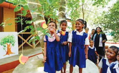 Schoolchildren in blue uniforms outside a cottage