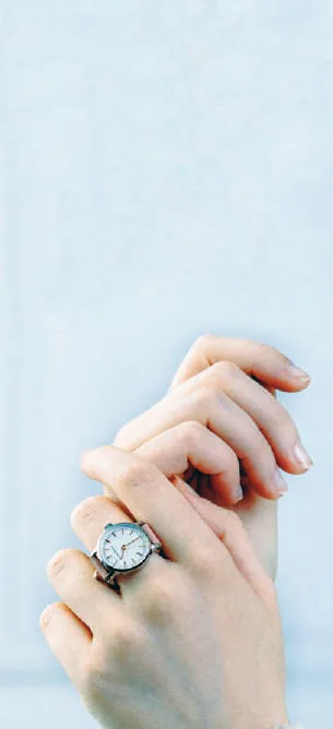 A hand wearing a ring watch