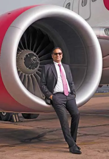 Ajay Singh, Chairman & Managing Director of SpiceJet, standing beside an aircraft engine