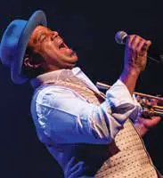 A jazz musician in a hat singing into a microphone