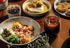 Plates of food and a glass of juice on a wooden table