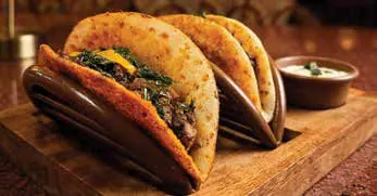 Two filled tacos on a wooden board