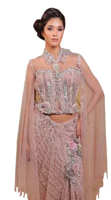 A model in an embellished blush-pink corset, skirt and cape