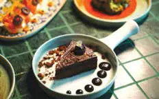 A slice of chocolate cake served in a small pan