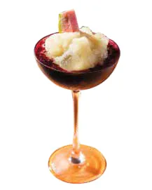 A frozen dessert in a tall glass, garnished with watermelon