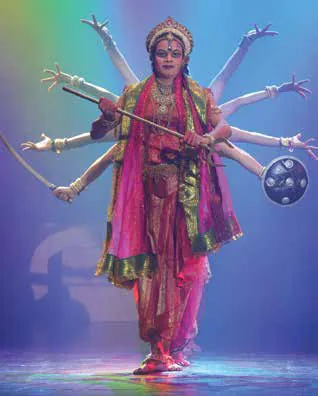 A dancer in a multi-armed goddess costume on stage