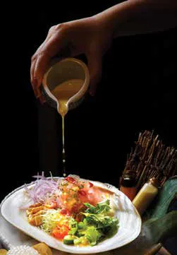 Sauce being poured over a plated dish