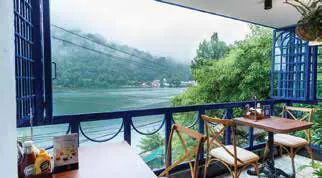 A view of a lake and hills from a café balcony