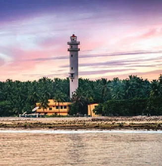 A lighthouse above the sea at sunset