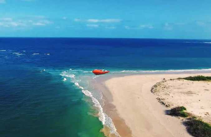 A beach below green cliffs